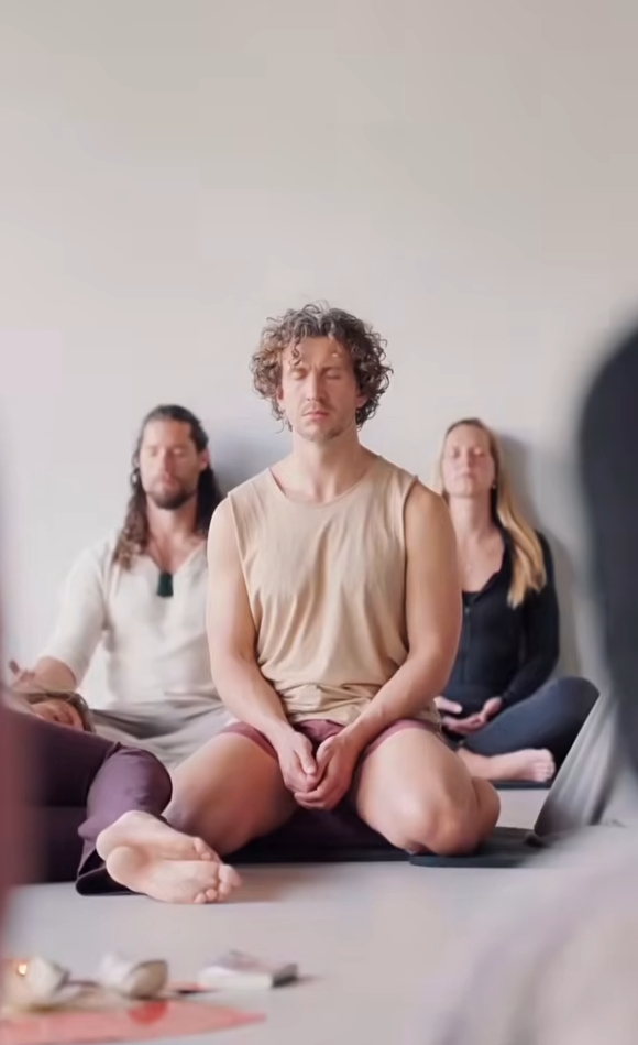 Deelnemers vertragen en ontspannen tijdens de lichaamsgerichte afsluiting van de Holistic Movement Experience.