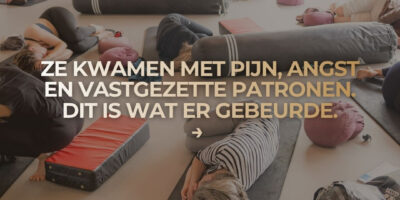 Deelnemers liggen tijdens een Holistic Movement groepssessie op matten en werken aan lichaamsbewustzijn, ontspanning en vertrouwen in hun lichaam.